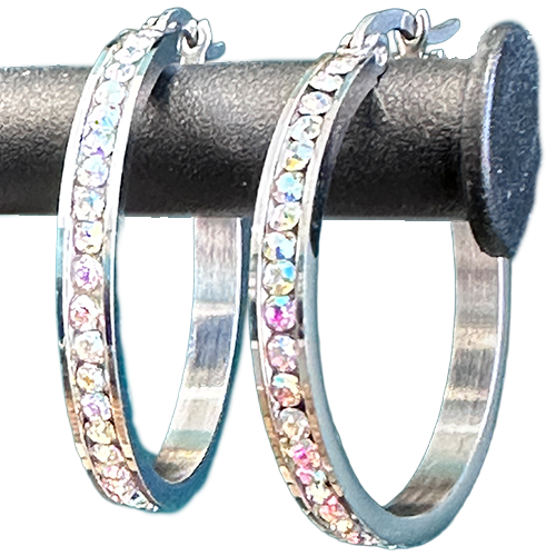 A pair of silver-colored hoop earrings with iridescent crystals set along the hoop, displayed against a black background.