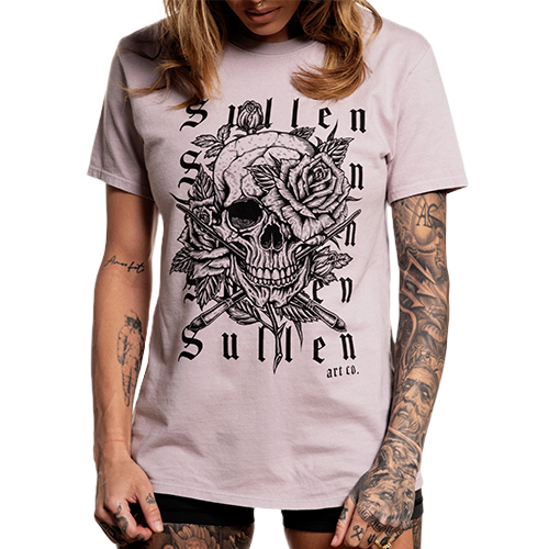 A female model wearing a light purple t-shirt with a graphic of a skull and roses.