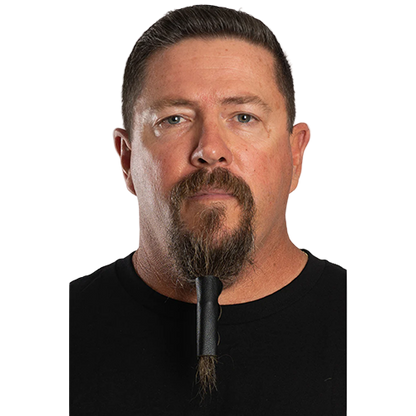 A man with a beard wearing a solid black beard glove.