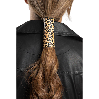 A person wearing a black leather jacket with a 4-inch leopard print leather hair glove in their hair.