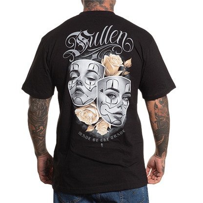 A person wearing a black crew neck t-shirt with a graphic design of two dramatic faces surrounded by golden roses on the back.