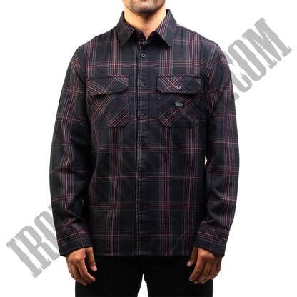 A man wearing a long-sleeved, black, red, and grey plaid flannel shirt.