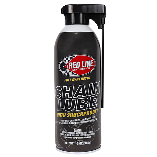 A bottle of Red Line Chain Lube with ShockProof, primarily in black with red and white accents, indicating it is a fully synthetic lubricant for chains.