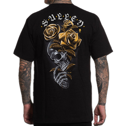 A person wearing a black t-shirt with a graphic design of a skeleton clutching three golden roses, and the brand name 'SULLEN' across the top.