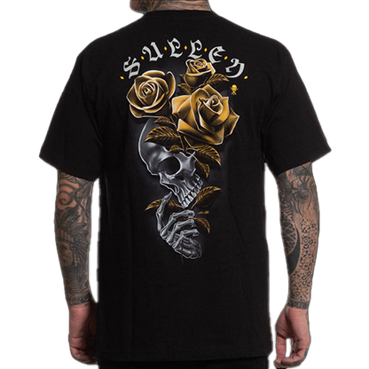 A person wearing a black t-shirt with a graphic design of a skeleton clutching three golden roses, and the brand name 'SULLEN' across the top.