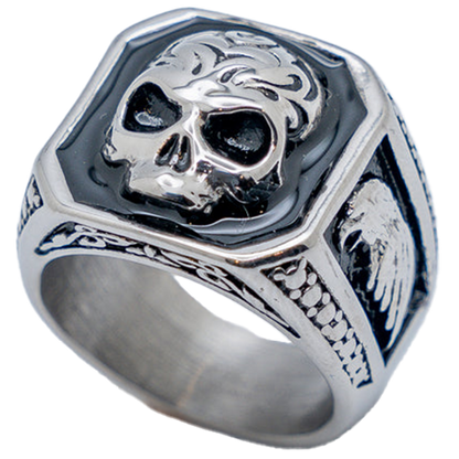 A stainless steel ring with a square top design featuring a skull in black contrast and eagle side details.