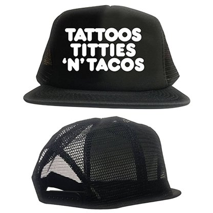 Black trucker hat with white text 'TATTOOS TITTIES 'N' TACOS' on a white background