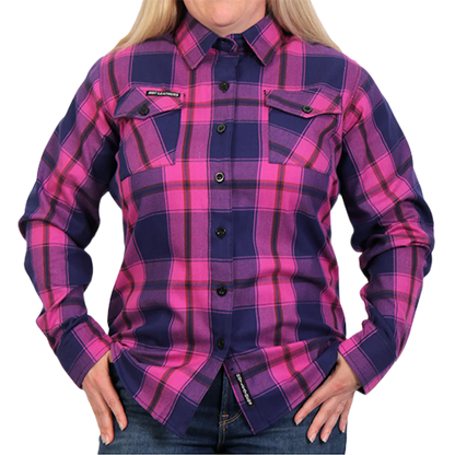 A woman wearing a long-sleeved flannel shirt with a plaid pattern in pink, navy, and brown colors, buttoned at the front.